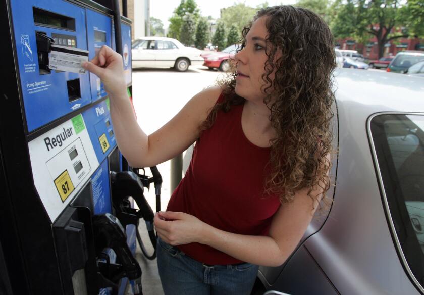 A woman swipes her credit card at a gas pump in 2007.
