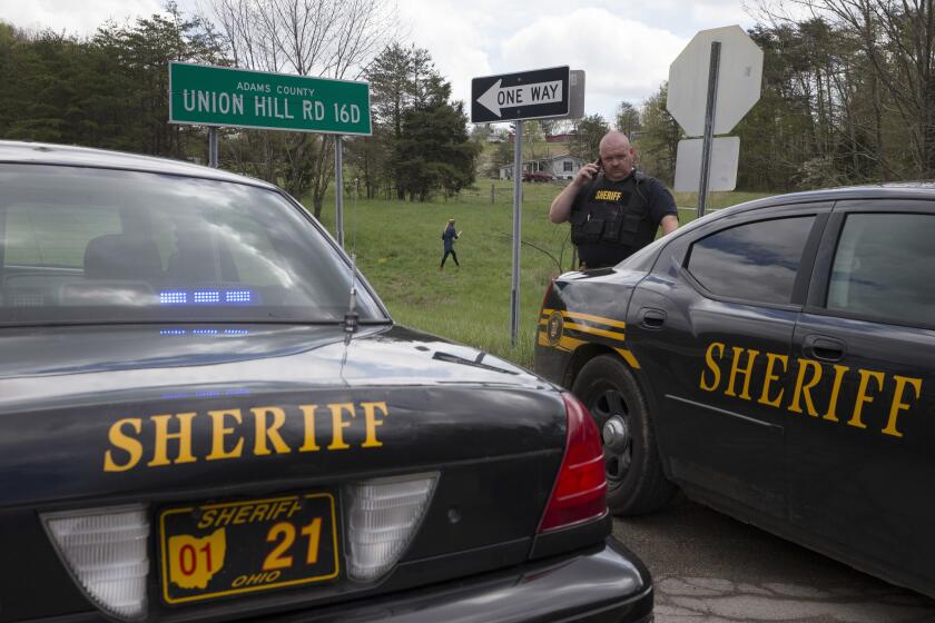 Authorities create a perimeter near the scene of multiple fatal shootings in Pike County, Ohio, on Friday.