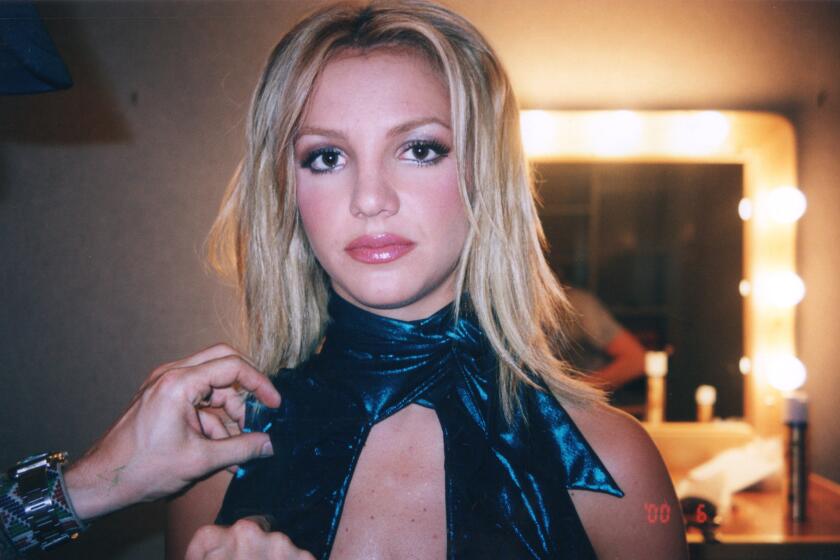 Britney Spears looking at the camera while wearing a blue costume