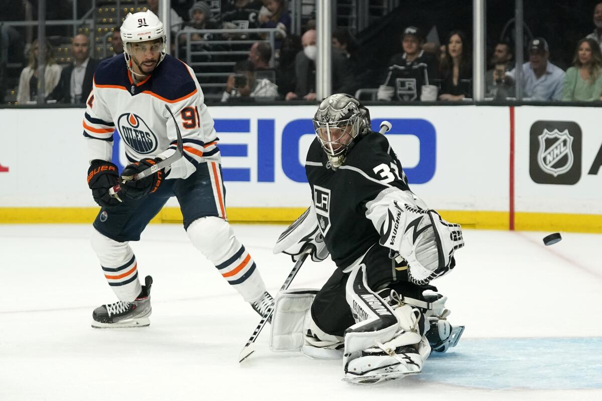 Kings goaltender Jonathan Quick deflects a shot in front of Edmonton Oilers left wing Evander Kane.