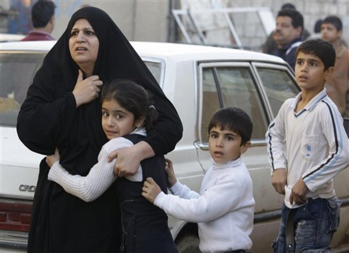 An Iraqi women hugs her daughter at the site of a car bomb attack in Baghdad, Iraq, Tuesday, Dec. 15, 2009. A series of car bombs ripped through downtown Baghdad near the heavily fortified Green Zone. (AP Photo/Hadi Mizban)