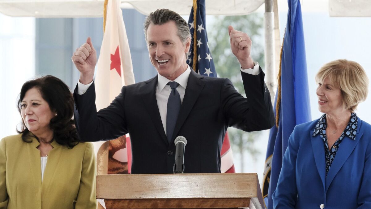 Gov. Gavin Newsom speaks at a news conference Wednesday flanked by L.A. County Supervisors Hilda Solis, left, and Janice Hahn at Rancho Los Amigos National Rehabilitation Center in Downey.