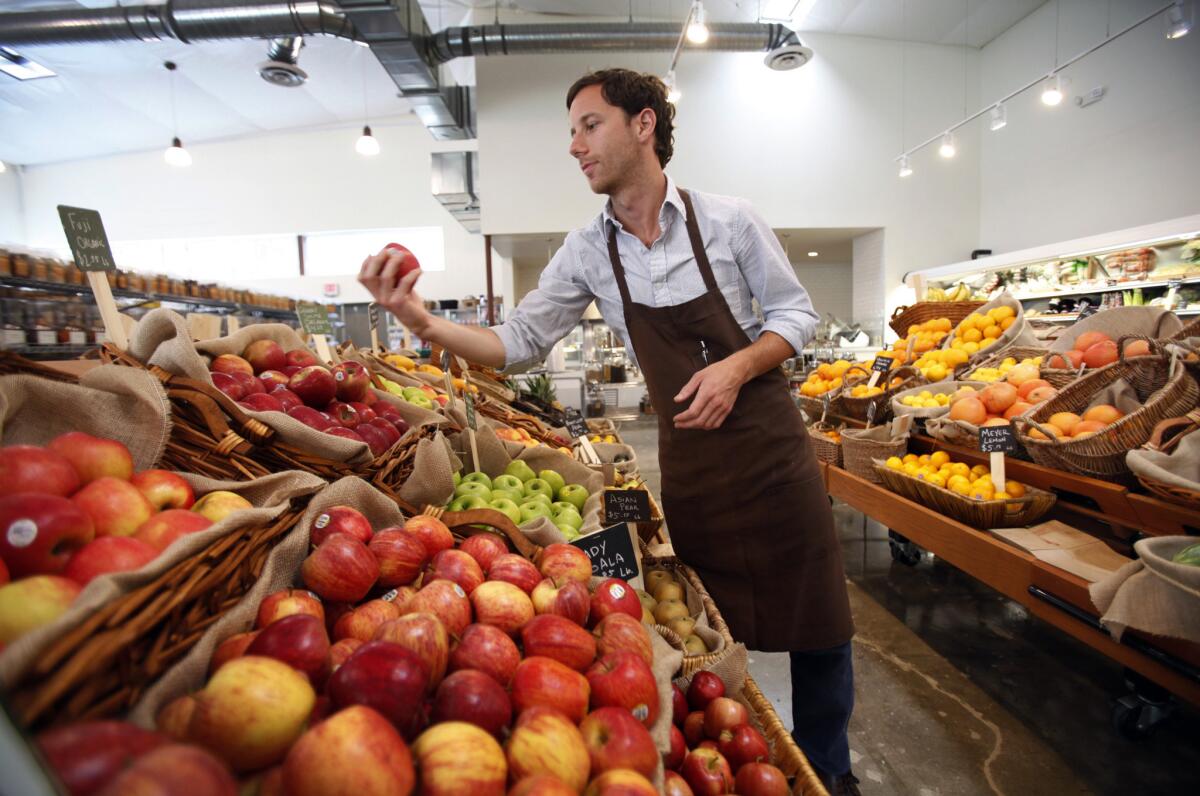 Andrew Lambert checks on produce at the Urban Radish grocery store in Los Angeles on July 10, 2013.