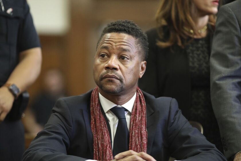 Cuba Gooding Jr. sitting in a suit looks slightly to his right