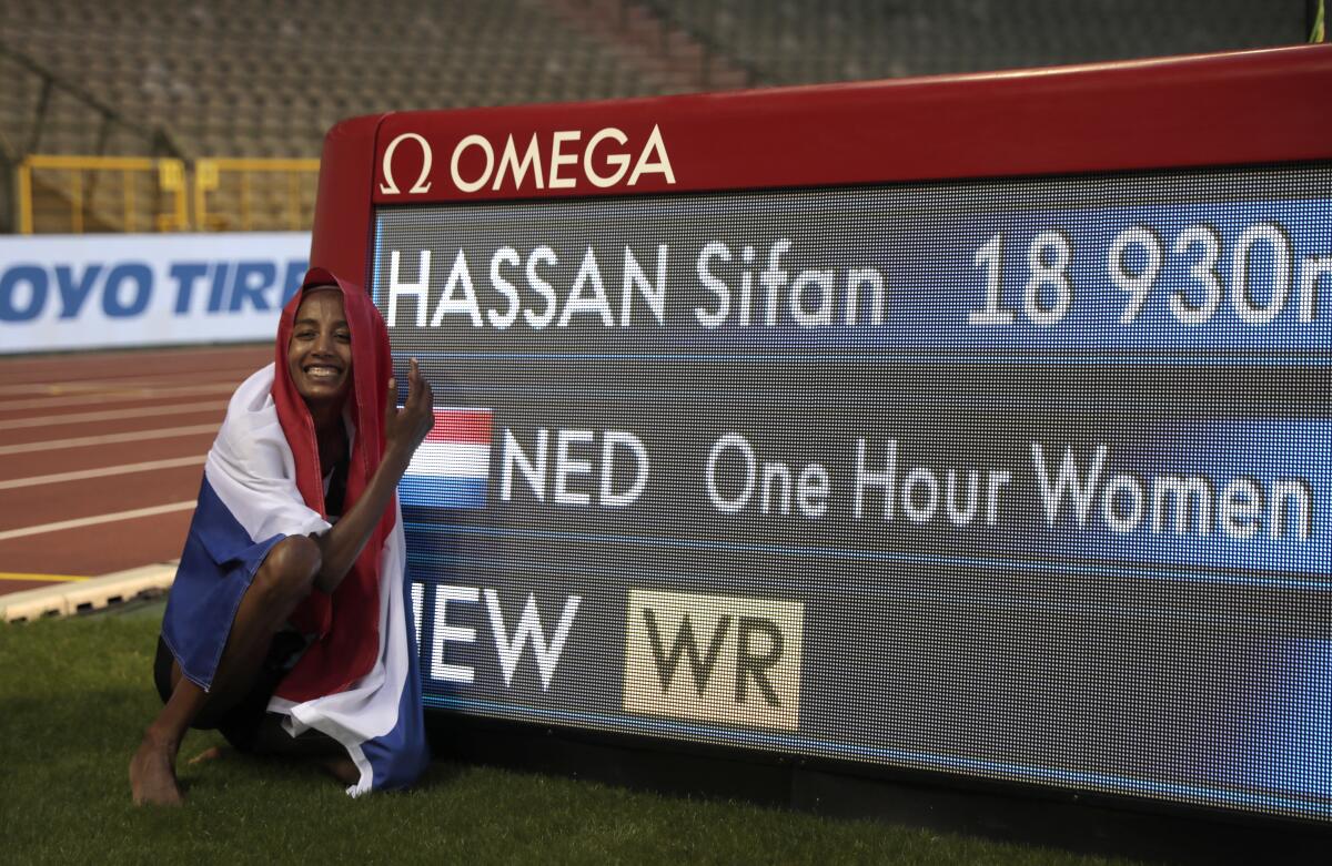 La holandesa Sifan Hassan posa junto a una pantalla luego de imponer un nuevo récord mundial.