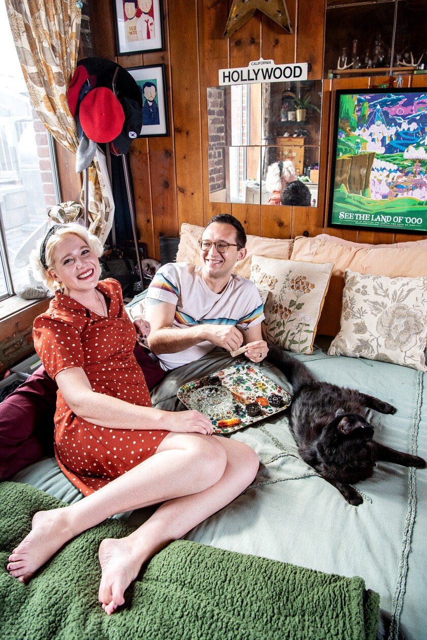 Two people and a cat on a bed.
