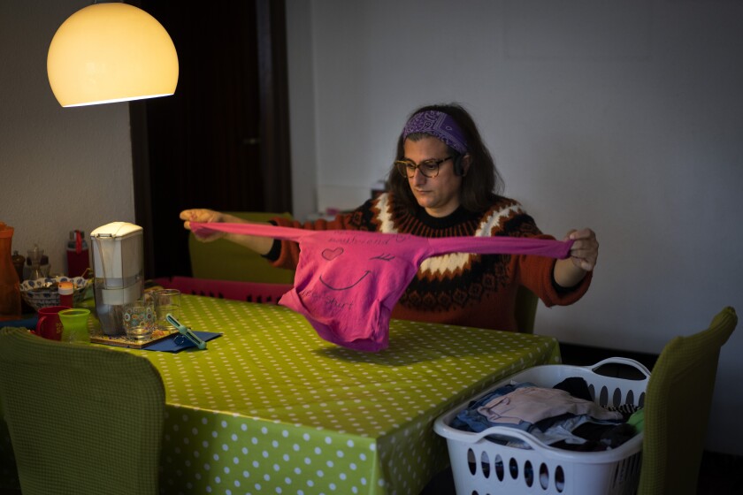 Victoria Martinez, 44, folds clothes at her home in Barcelona, Spain, Monday, Feb. 8, 2021. By May this year, barring any surprises, Martinez will complete a change of both gender and identity at a civil registry in Barcelona, finally closing a patience-wearing chapter that has been stretched during the pandemic. The process, in her own words, has also been “humiliating.” (AP Photo/Emilio Morenatti)