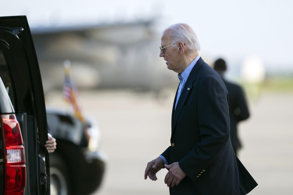 President Biden walks to an SUV. 