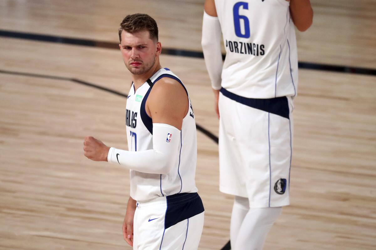 Dallas Mavericks guard Luka Doncic, left, reacts during a playoff game against the Clippers.