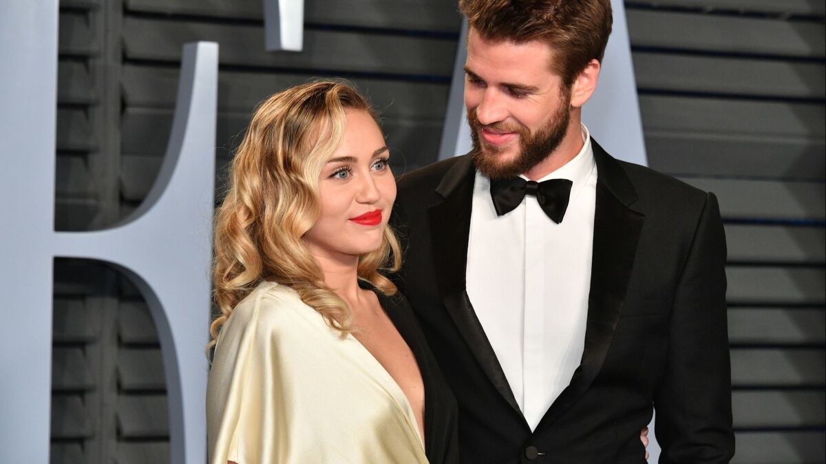 Miley Cyrus, left, and Liam Hemsworth, seen here at the 2018 Vanity Fair Oscar party, have married,