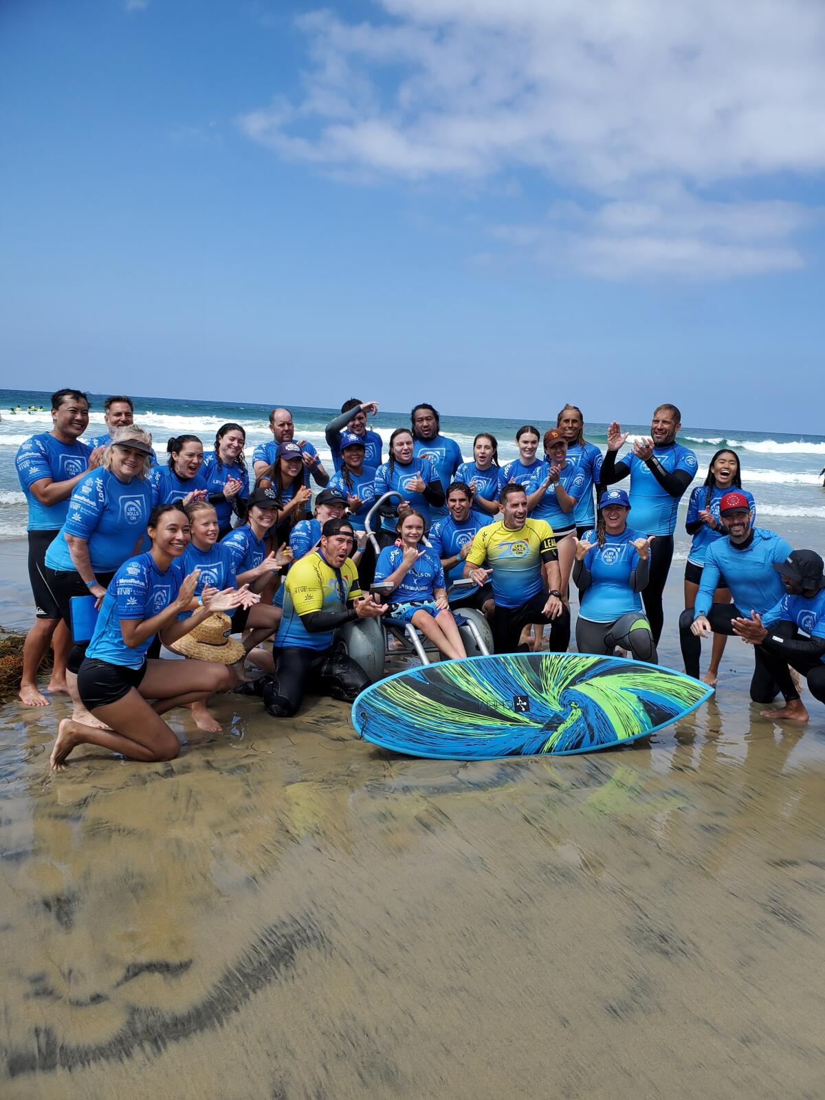 Life Rolls On volunteers prepare to take a surfer out on the waves with adaptive equipment.