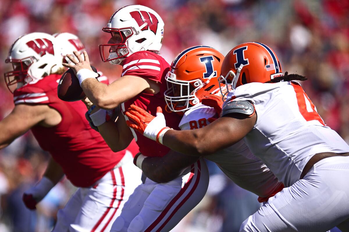 Wisconsin quarterback Graham Mertz (5) is sacked by Illinois defensive lineman Keith Randolph Jr. (88) and teammate Jer'Zhan Newton (4) during the second half of an NCAA college football game Saturday, Oct. 1, 2022, in Madison, Wis. (AP Photo/Kayla Wolf)