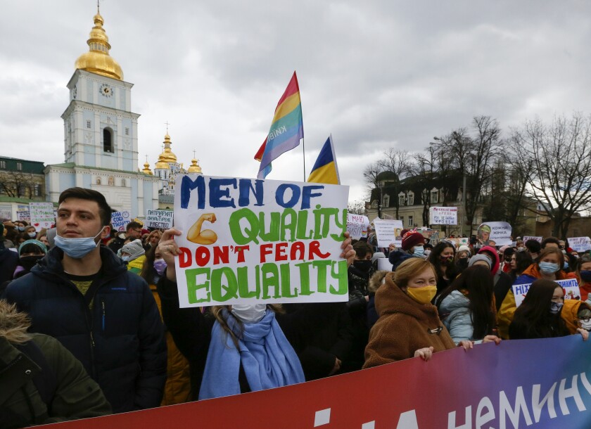 Activists shouts slogans at a rally on the occasion of the International Women's Day in Kyiv, Ukraine, Monday, March 8, 2021. Millions across the globe are marking International Women's Day by demanding a gender-balanced world amid persistent salary gap, violence and widespread inequality. (AP Photo/Efrem Lukatsky)