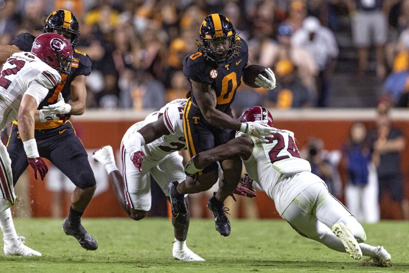 Tennessee running back Jaylen Wright (0) is tackled by South Carolina linebacker Bam Martin-Scott (22) and defensive back Jalon Kilgore (24) during the first half of an NCAA college football game Saturday, Sept. 30, 2023, in Knoxville, Tenn. (AP Photo/Wade Payne)
