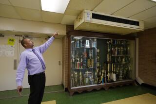 Jim Hill High School principal Bobby Brown, points out one of the outdated air-condition units that are installed throughout the Jackson, Miss., school, Jan. 12, 2023. A litany of infrastructure issues in the nearly 60-year-old school make for tough choices on spending COVID recovery funds on infrastructure or academics. (AP Photo/Rogelio V. Solis)