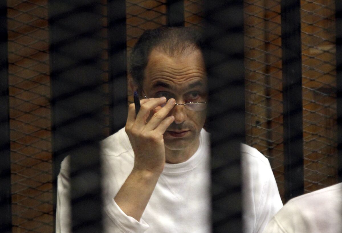 FILE - Gamal Mubarak sits behind bars at the second session of his trial on charges of insider trading in Cairo Criminal Court in Cairo, Egypt, on Sept. 8, 2012. Mubarak, the son of Egypt's former president said Tuesday, May 17, 2022, that he and family members were innocent of corruption charges made in international courts after the country’s 2011 popular uprising. His statements came after years of attempts by the deposed president's family to rehabilitate its image as it faced litigation in Egypt and abroad. (AP Photo/Ahmed Gomaa, File)