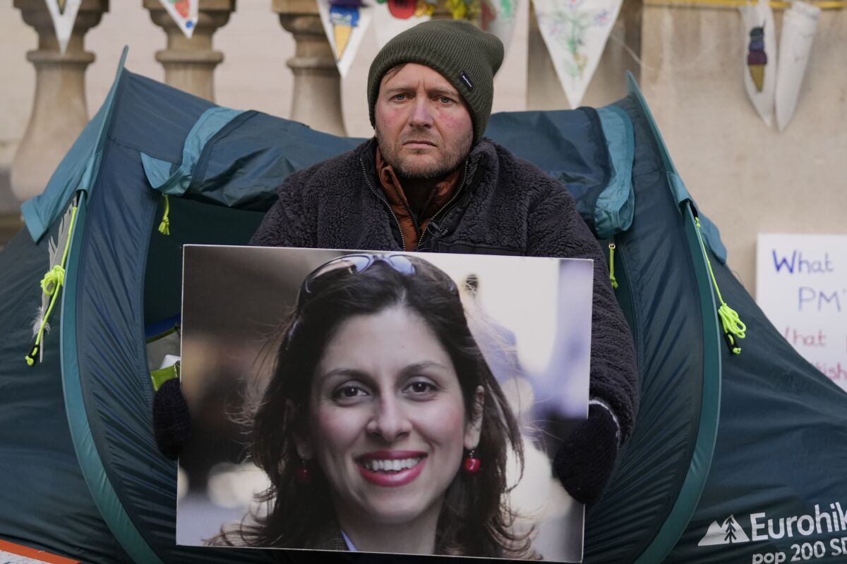 FILE - Richard Ratcliffe, the husband of detained charity worker Nazanin Zaghari-Ratcliffe, holds her photo outside the Foreign, Commonwealth and Development Office in London, on Nov. 9, 2021. Iranian authorities have returned the passport of a U.K. charity worker who has been detained for more than five years, raising hopes that she could be released. (AP Photo/Frank Augstein)