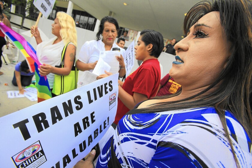 Mitzy Garcia, right, of Pomona, and other members of the LGBT community and their supporters hold a rally in August 2014 to protest the rape of a transgender woman in an immigrant detention facility.