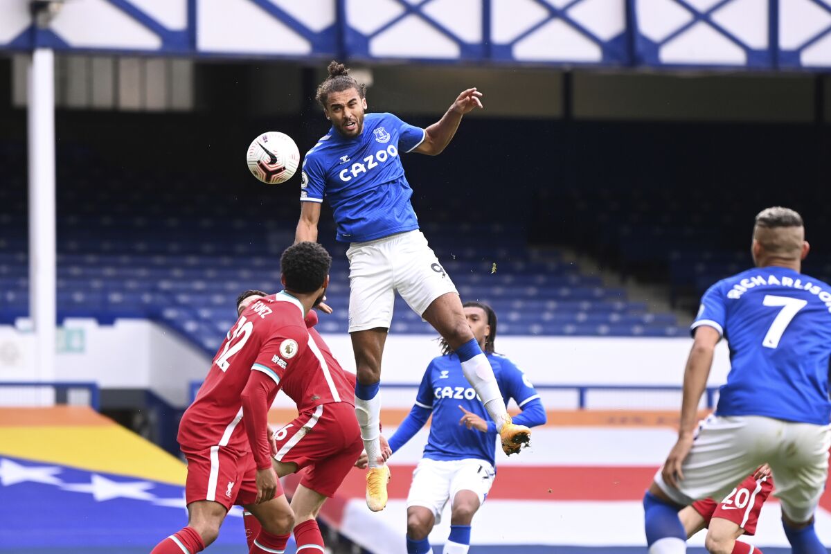 Everton's Dominic Calvert-Lewin, top, scores his side's second goal to make the score 2-2 during the English Premier League soccer match between Everton and Liverpool at Goodison Park stadium, in Liverpool, England, Saturday, Oct. 17, 2020. (Laurence Griffiths/Pool via AP)