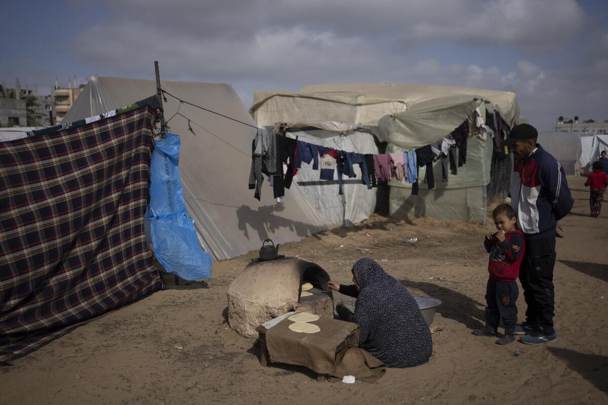 Palestinos desplazados por la ofensiva terrestre israelí en la Franja de Gaza cocinan