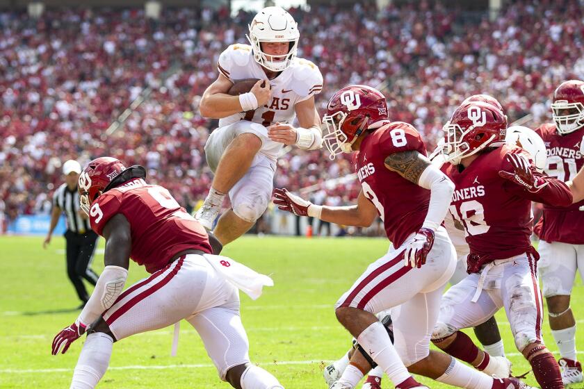 FILE - In this Oct. 6, 2018, file photo, Texas quarterback Sam Ehlinger (11) leaps into the end zone to score against Texas during an NCAA college football game at the Cotton Bowl in Dallas. The Texas-Oklahoma rivalry is never short on bad blood between the Big 12 border states. (Nick Wagner/Austin American-Statesman via AP, File)