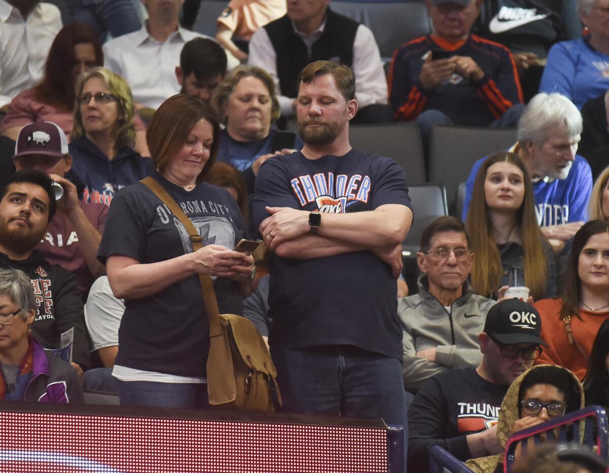Basketball fans react after the announcement that a game between the Oklahoma City Thunder and the Utah Jazz on March 11 at Chesapeake Energy Arena has been postponed just before tip-off.