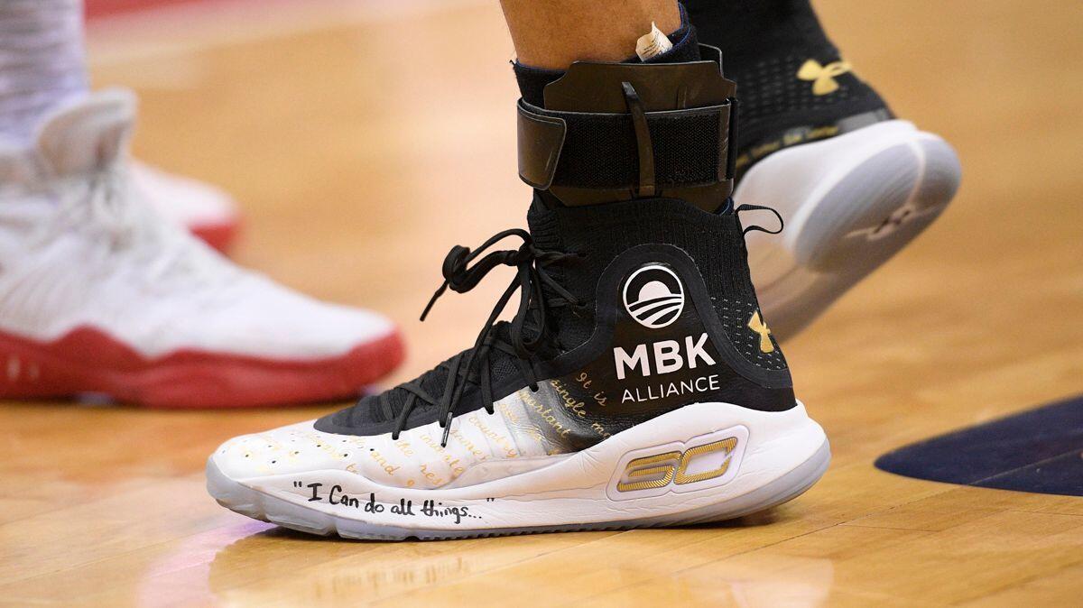 Golden State Warriors guard Stephen Curry's shoes are adorned with messages during the first half of the team's game against the Washington Wizards on Wednesday.