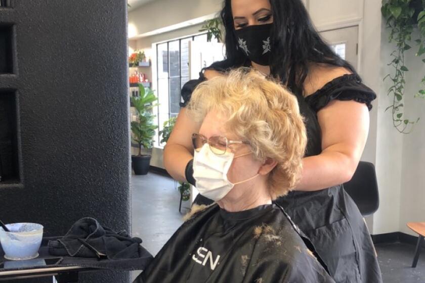 Ashley Kouza does Jo Anne Moran's hair at Velvet Hair Lounge, while both wear masks to follow public health guidelines.