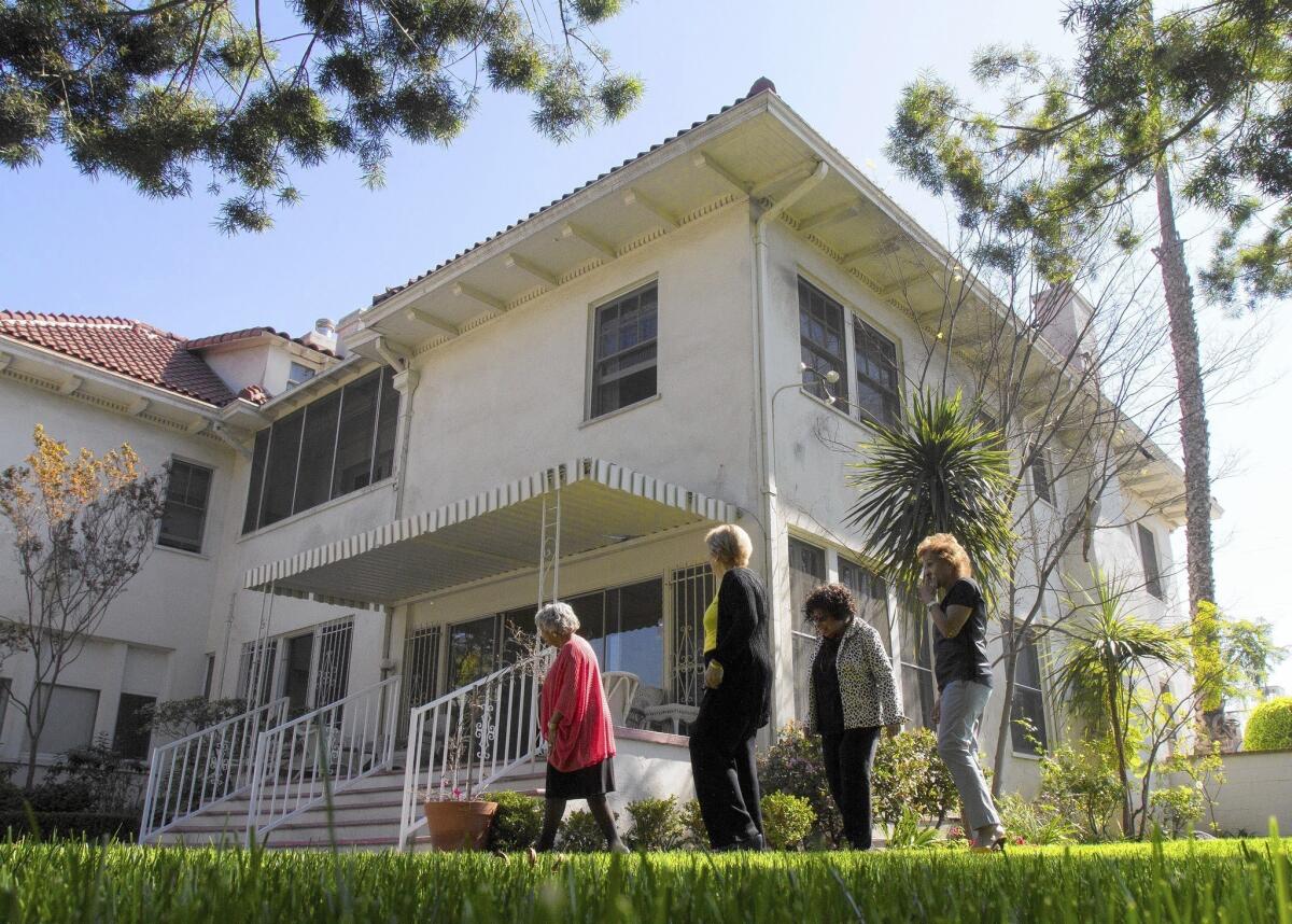 Wilfandel Club President Carol Kaiser, left, Anne Luke, Gloria Hill and Heilindia Brown stroll through the garden at the Wilfandel House. Club members are raising money to restore the house.