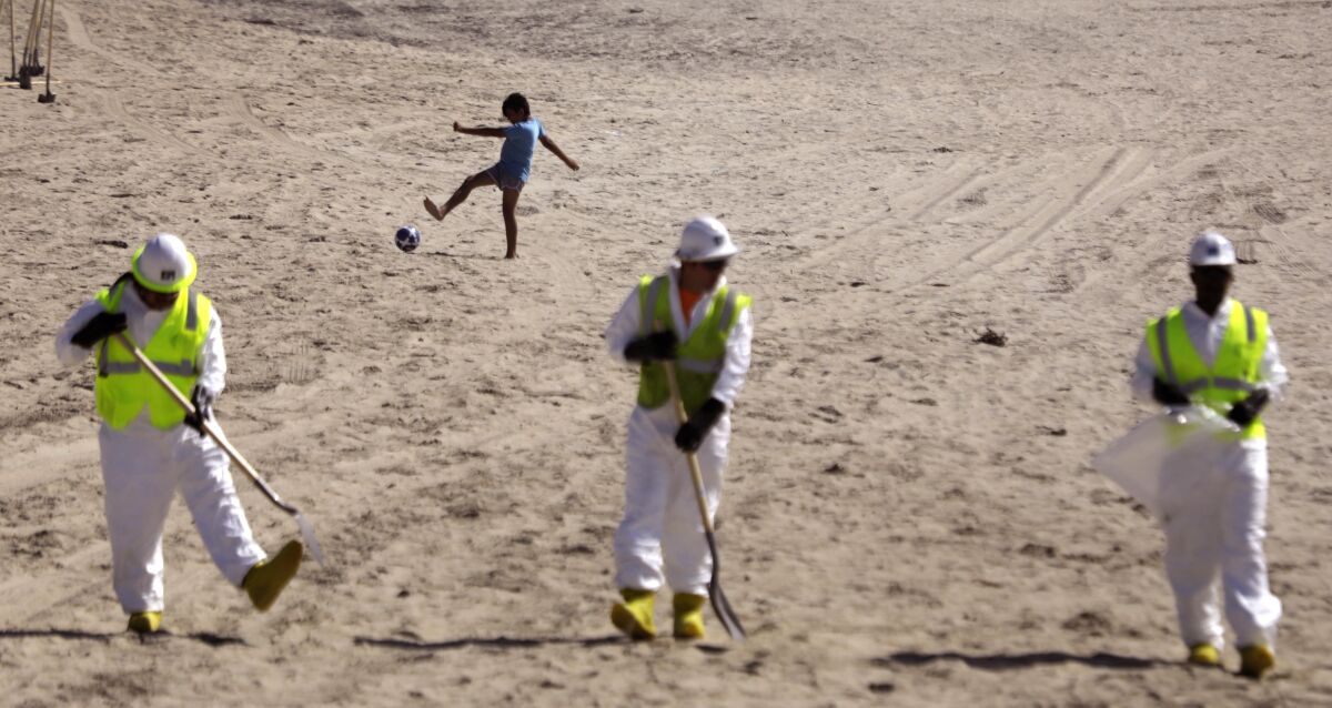  Workers continue cleaning the beach.