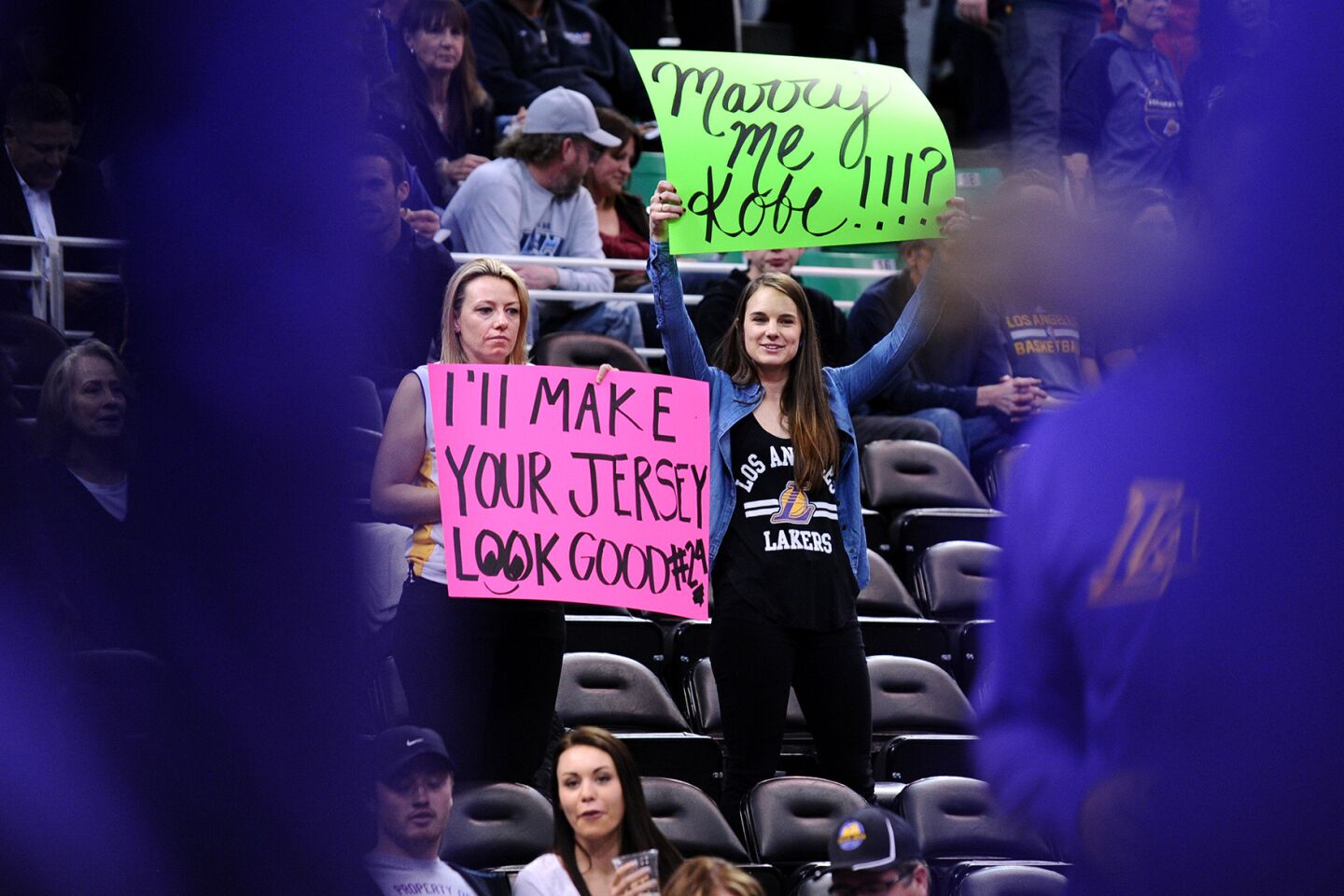 Fans hold signs as Kobe Bryant warms-up before a game with the Jazz in Salt Lake City on March 28.