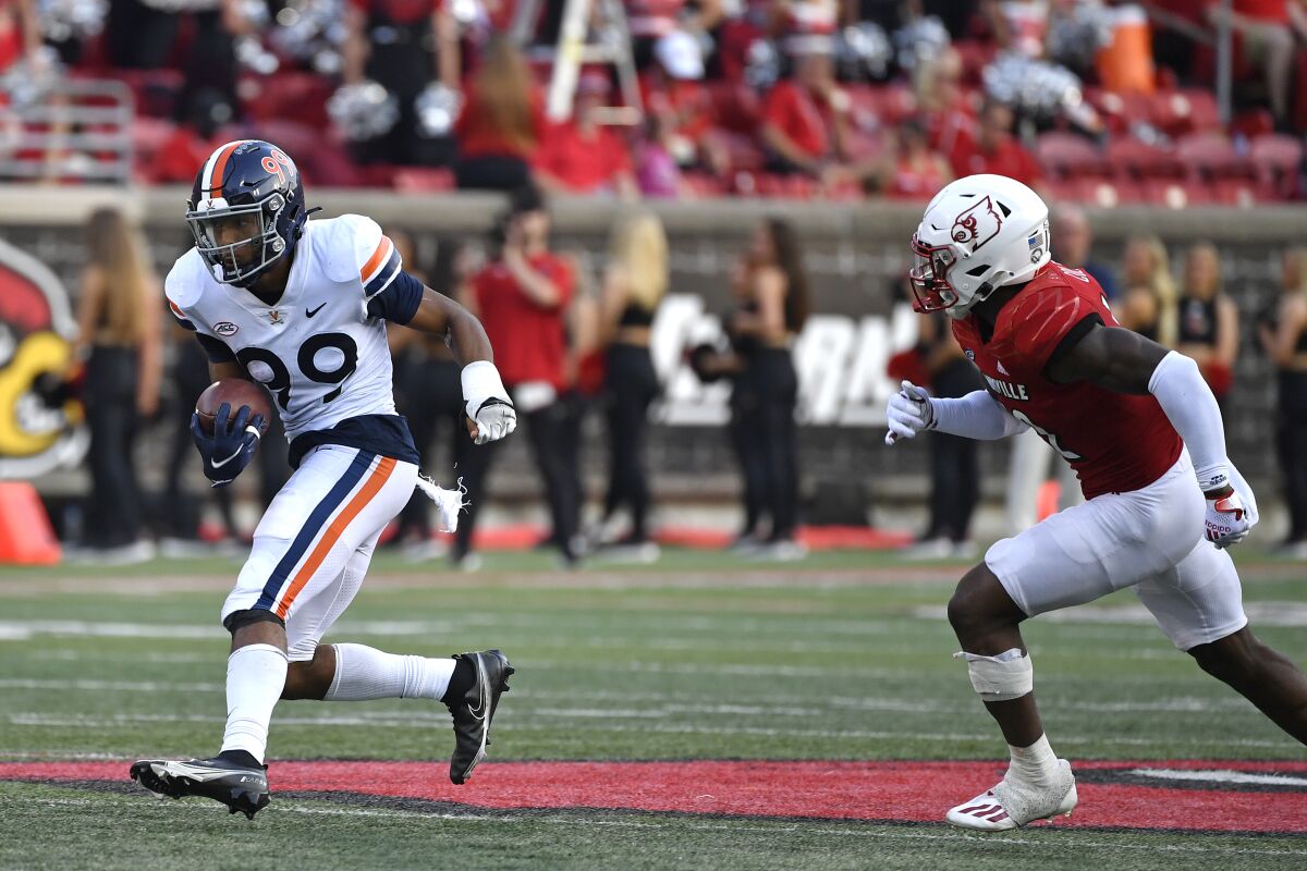Virginia wide receiver Keytaon Thompson (99) is chased by Louisville defensive back Qwynnterrio Cole (12) during the second half of an NCAA college football game in Louisville, Ky., Saturday, Oct. 9, 2021. Virginia won 34-33. (AP Photo/Timothy D. Easley)