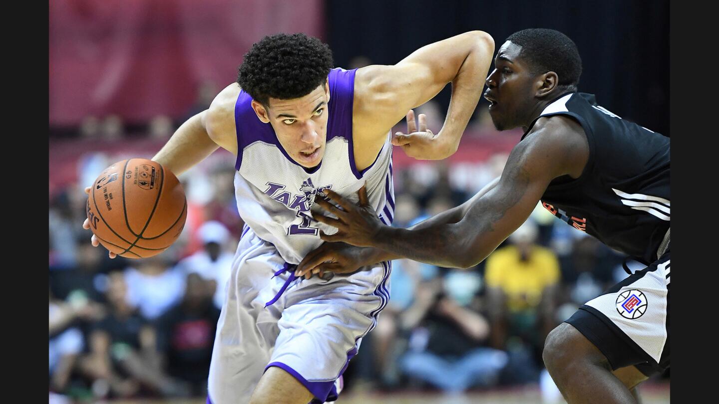 Lakers rookie point guard Lonzo Ball dribbles past Clippers guard Juwan Evans during the first quarter.