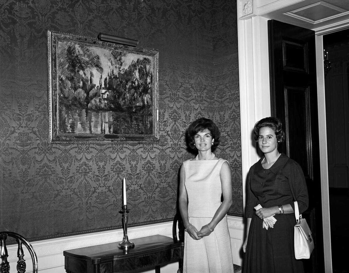 First Lady Jacqueline Kennedy stands with Philippa Calnan, the donor's granddaughter, in front of Cézanne's "House on the Marne" in the White House's Green Room on June 28, 1961.