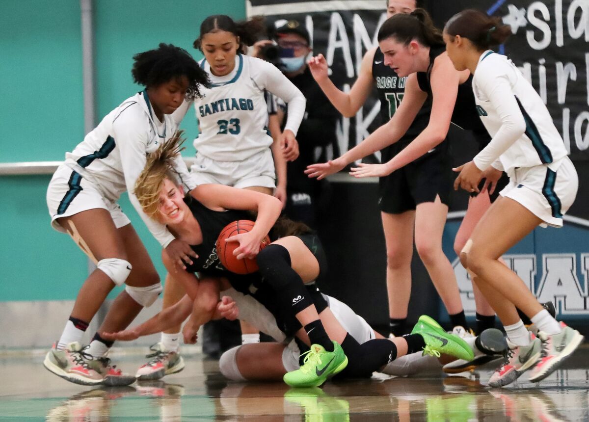 Sage Hill's Annabelle Spotts secures a rebound as she goes down in a scrum against Corona Santiago on Tuesday.