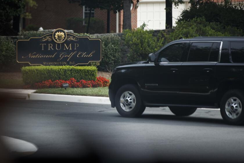 A motorcade carrying President Donald Trump arrives at Trump National Golf Club, Monday, Sept. 2, 2019, in Sterling, Va., as seen through the window of a van traveling with the President. (AP Photo/Evan Vucci)