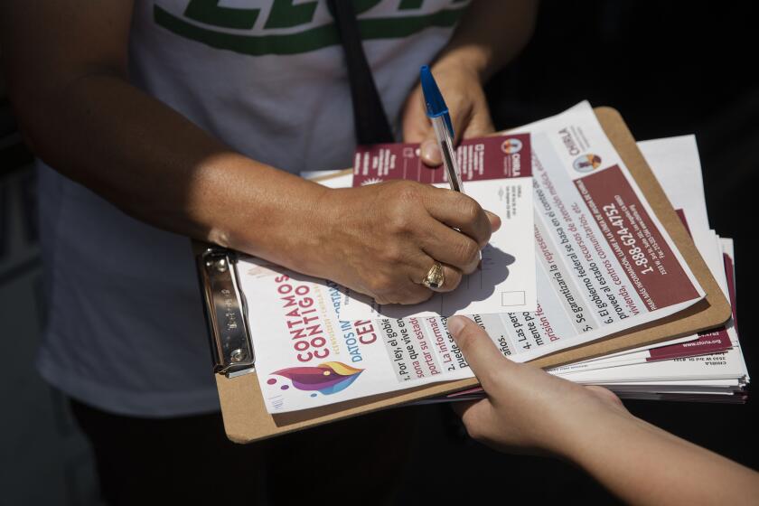 LOS ANGELES, CALIF. - JULY 23, 2019: America Barrera, 15, youth volunteer with CHIRLA, helps Mercedes N. Martinez sign up for the census in MacArthur Park in Los Angeles, Calif. on Tuesday, July 23, 2019. (Liz Moughon / Los Angeles Times)