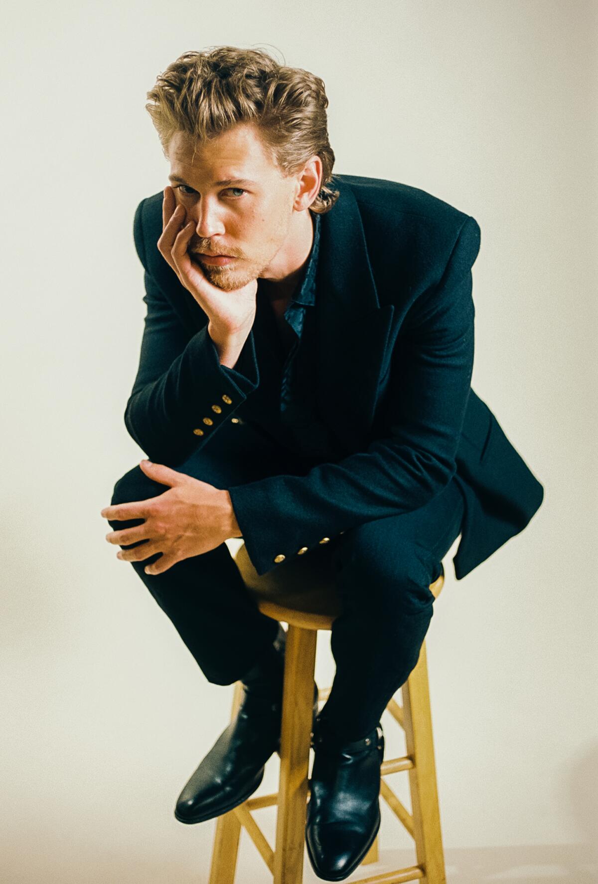 Actor Austin Butler sits on a stool looking at camera