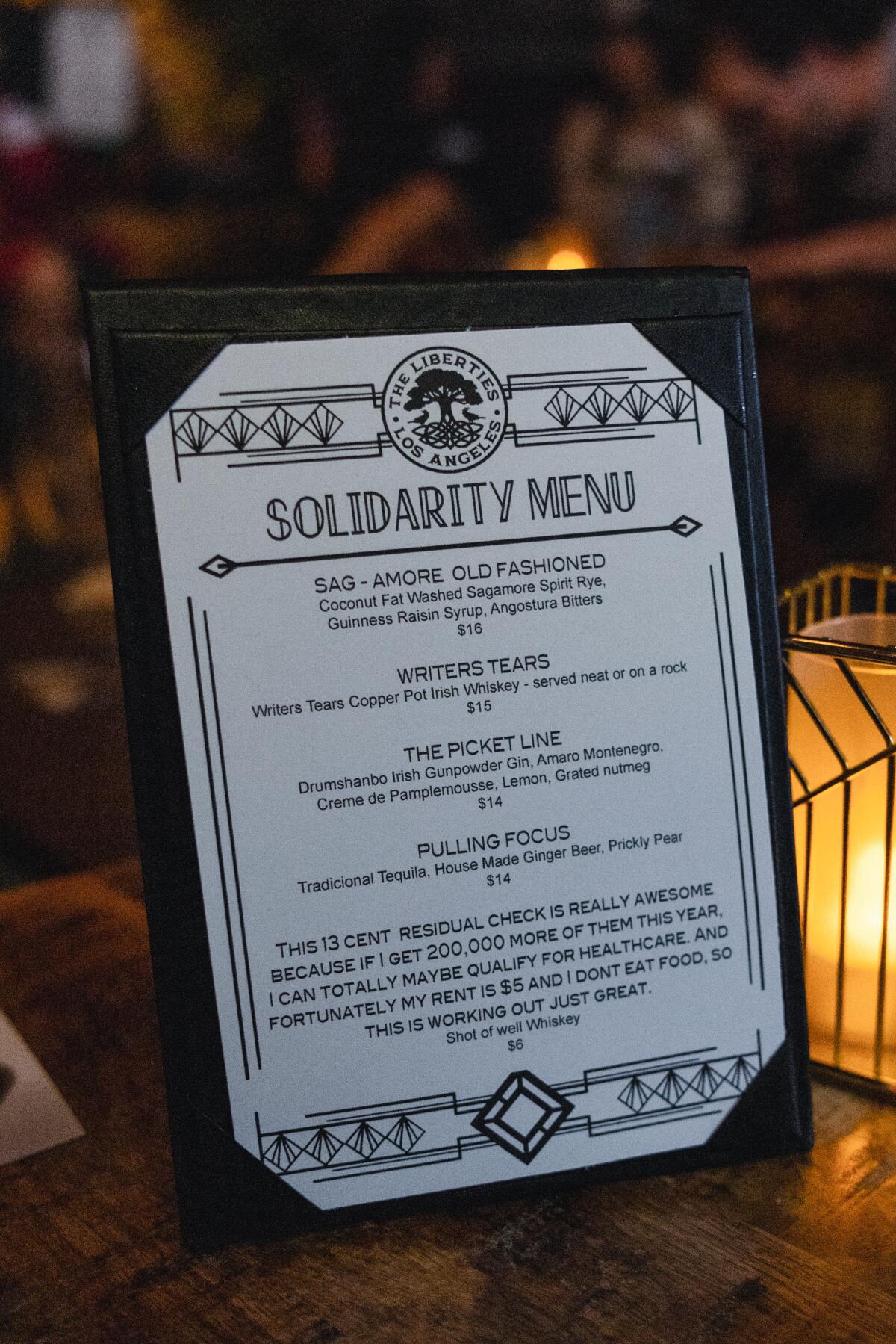 A "solidarity menu" listing SAG-AFTRA strike-themed drinks, on a table at the Liberties.
