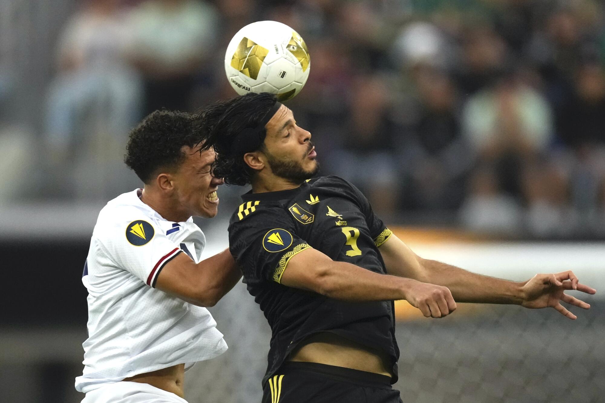 Dominican Republic midfielder Jean López, left, Mexico forward Raúl Jiménez battle for the ball.