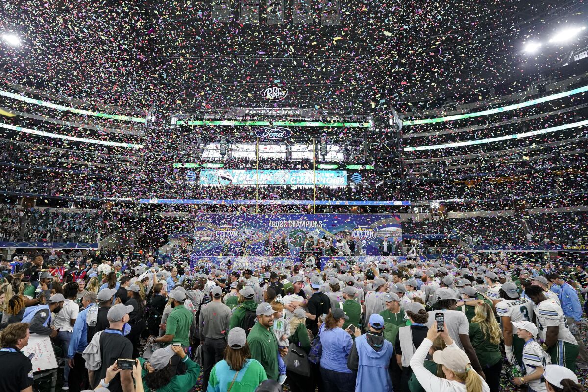 Tulane players and fans celebrate on the field after defeating USC.