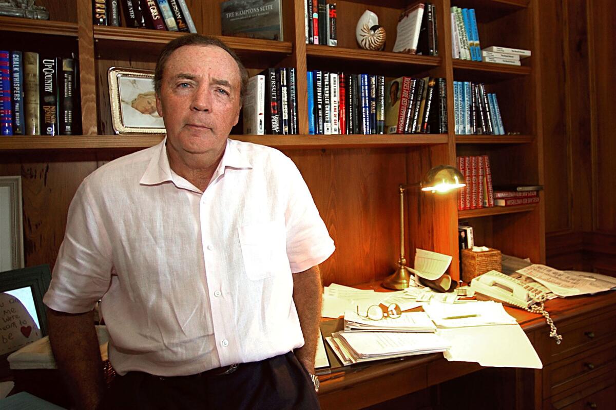 James Patterson in front of a desk and bookshelves