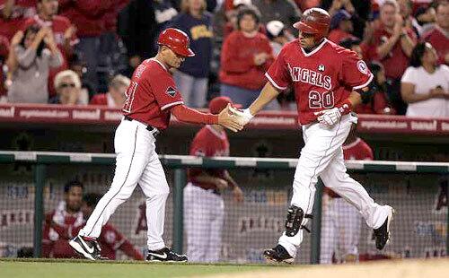 Angels left fielder Juan Rivera low-fives third base coach Dino Ebel after hitting a home run in the eighth inning Friday night to break a tie with the Dodgers.