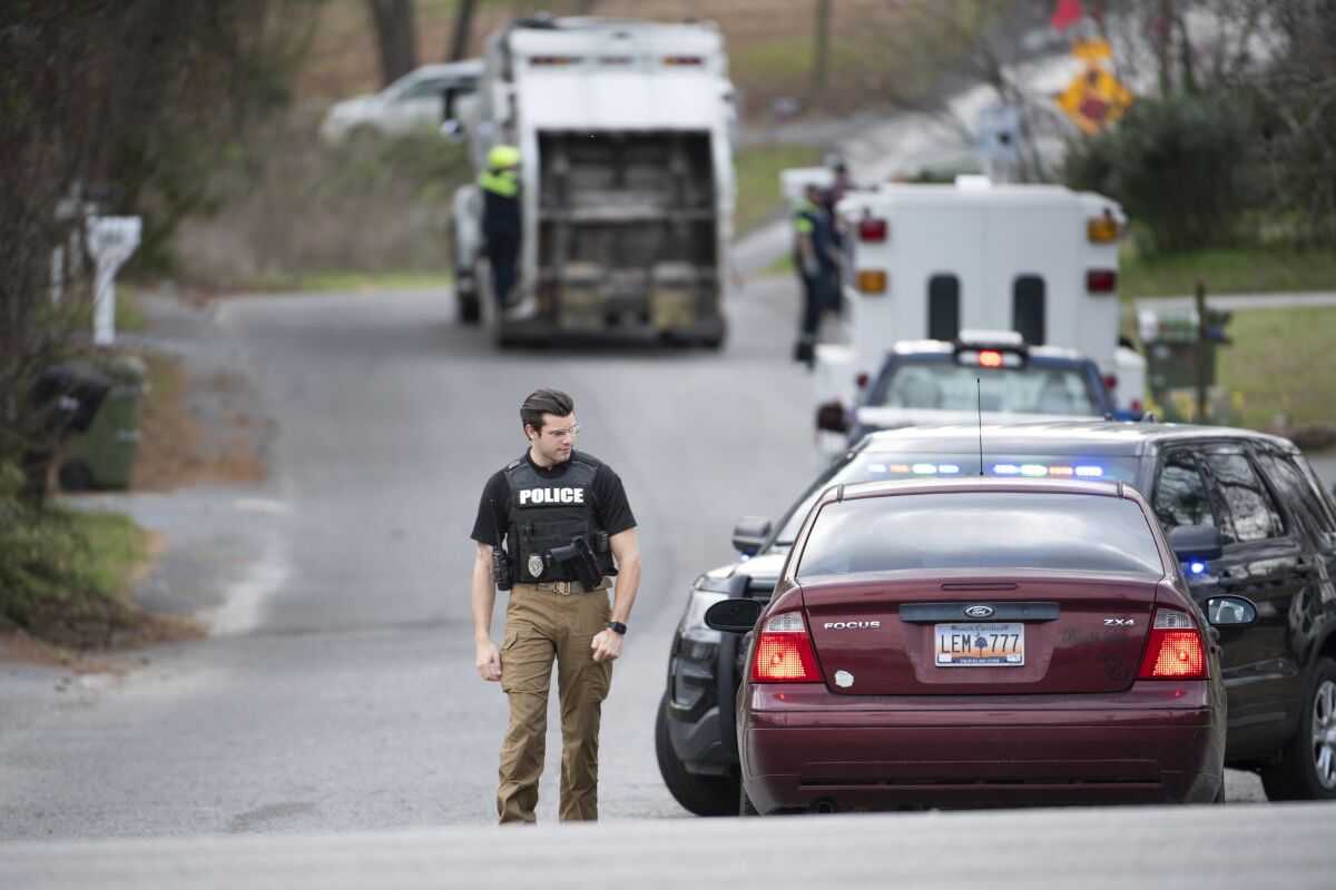 A Cayce police officer approaches a vehicle at a road block near an entrance to the Churchill Heights neighborhood Thursday, Feb. 13, 2020, in Cayce, S.C., where six year-old Faye Marie Swetlik recently went missing. Hundreds of officers in Cayce, along with state police and FBI agents, are working around the clock to try to find Swetlik, who was last seen Monday just after getting off a school bus, Cayce Public Safety Officer Sgt. Evan Antley reiterated Thursday. (AP Photo/Sean Rayford)
