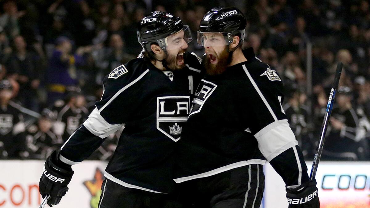 Kings defenseman Drew Doughty, left, celebrates with Jake Muzzin after Muzzin scored a goal against the Blues during the first period Thursday night.