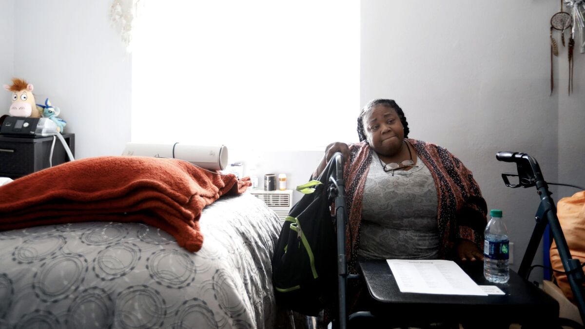 Natalie Purnell sits in her room at a former motel in South L.A. that is temporarily being used to house homeless women, run by the nonprofit First to Serve.