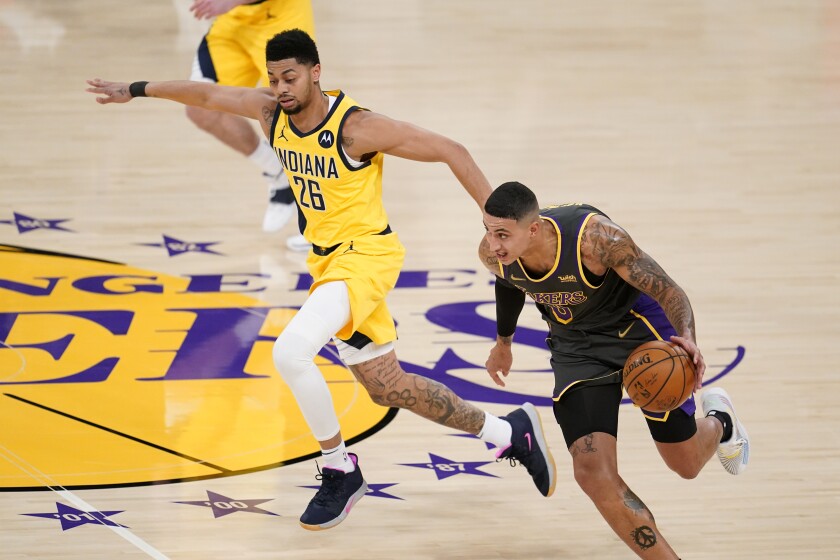 The Lakers' Kyle Kuzma dribbles past the Indiana Pacers' Jeremy Lamb during the first half March 12, 2021.
