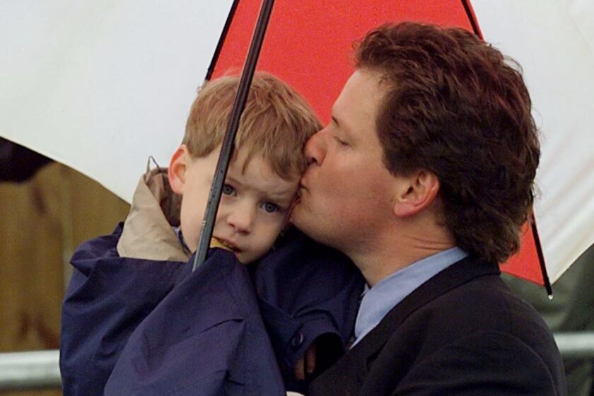 HOPE, UNITED STATES: US President Bill Clinton's brother Roger Clinton gives son Tyler Clinton a kiss under his umbrella during the dedication ceremony of Bill Clinton's childhood home 12 March in Hope, Arkansas. The 72-year-old home at 117 South Hervey is where the young Clinton spent his first four years. (ELECTRONIC IMAGE) AFP PHOTO/Stephen JAFFE (Photo credit should read STEPHEN JAFFE/AFP/Getty Images) ** OUTS - ELSENT, FPG, CM - OUTS * NM, PH, VA if sourced by CT, LA or MoD **