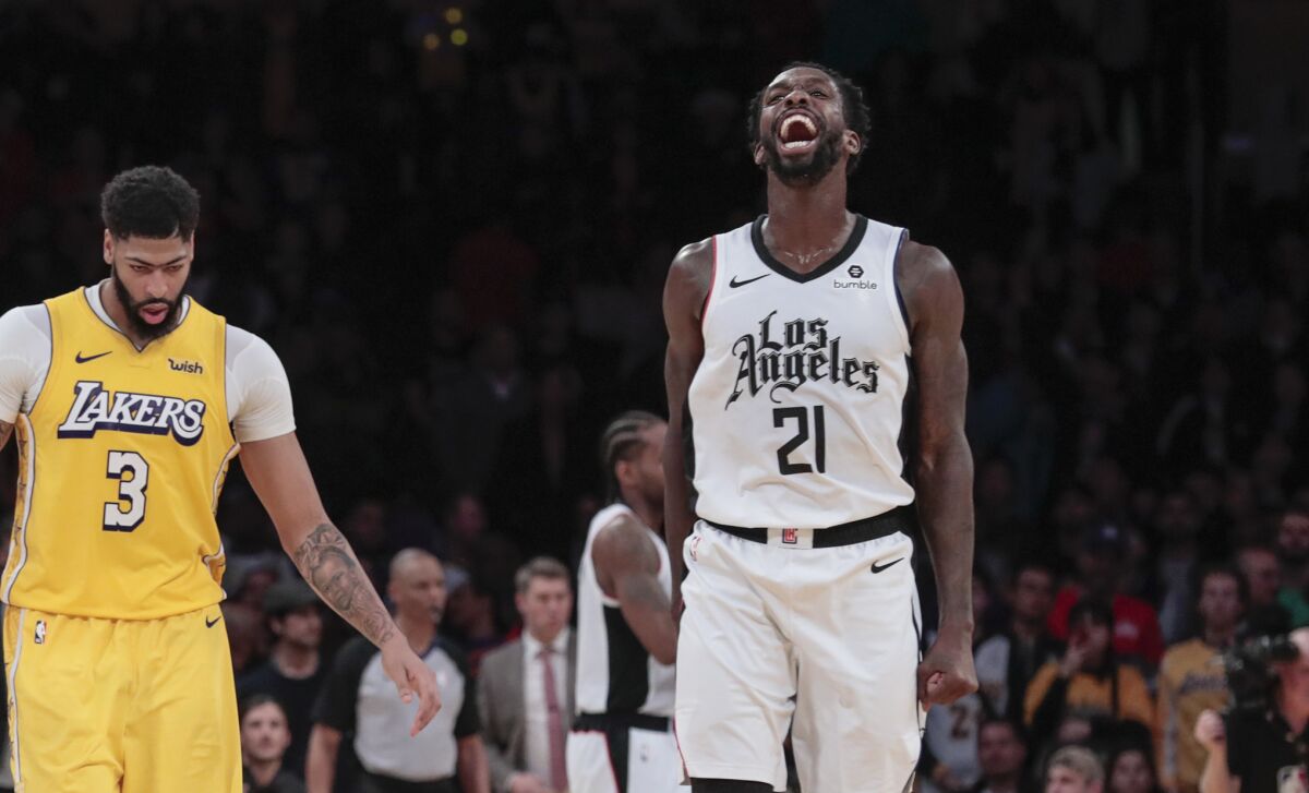Clippers guard Patrick Beverley (21) celebrates a 111-106 win after Lakers forward Anthony Davis (3) missed an inconsequential shot at the buzzer on Dec. 25, 2019.