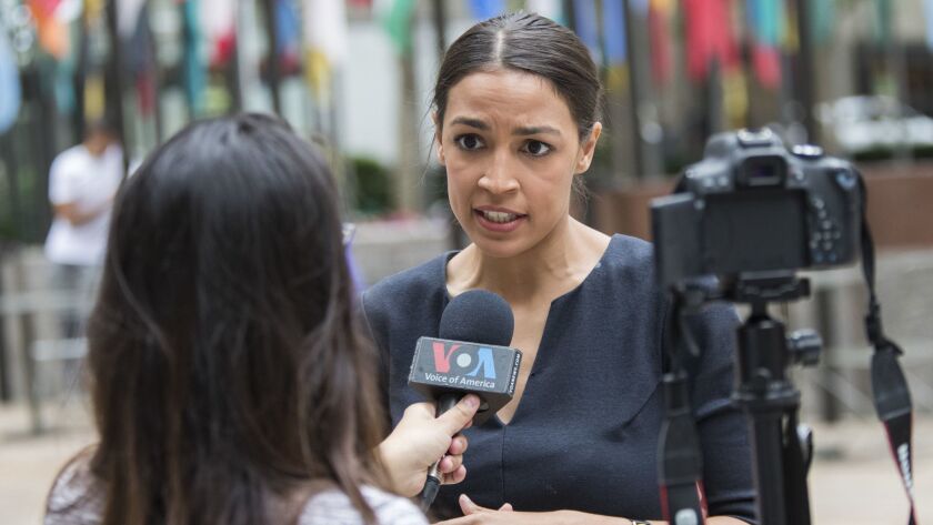 Alexandria Ocasio-Cortez, a winner of a Democratic Congressional primary in New York, speaks to a reporter.
